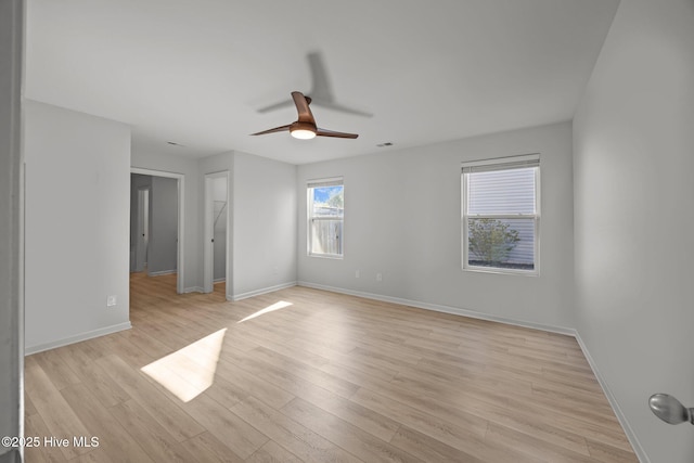 spare room with baseboards, visible vents, a ceiling fan, and light wood-style floors