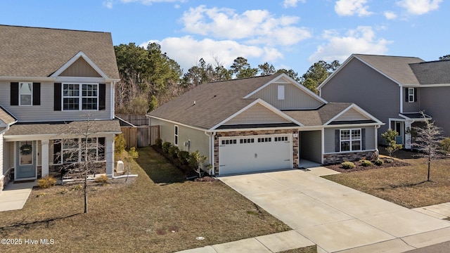 view of front of house featuring stone siding, fence, roof with shingles, concrete driveway, and an attached garage