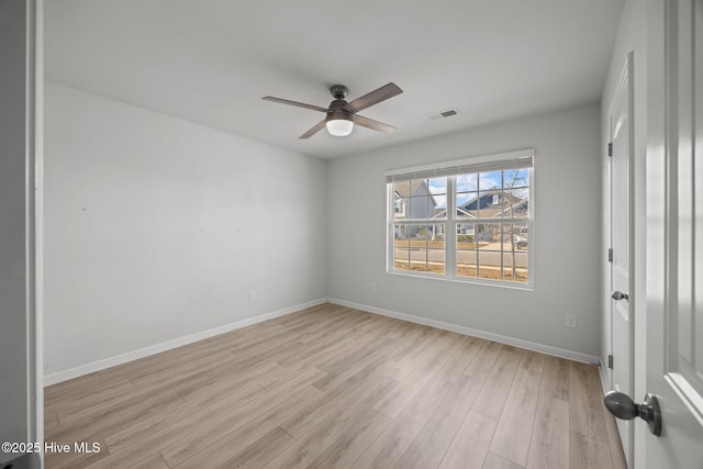 empty room with baseboards, light wood-style floors, visible vents, and ceiling fan