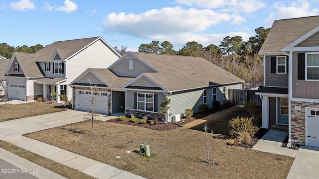 view of front facade featuring a garage, stone siding, roof with shingles, and concrete driveway