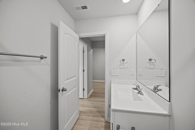 bathroom featuring visible vents, vanity, and wood finished floors