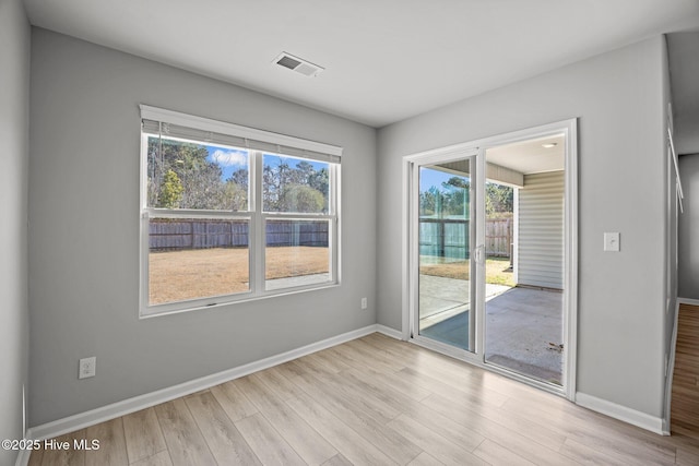 empty room featuring visible vents, baseboards, and wood finished floors