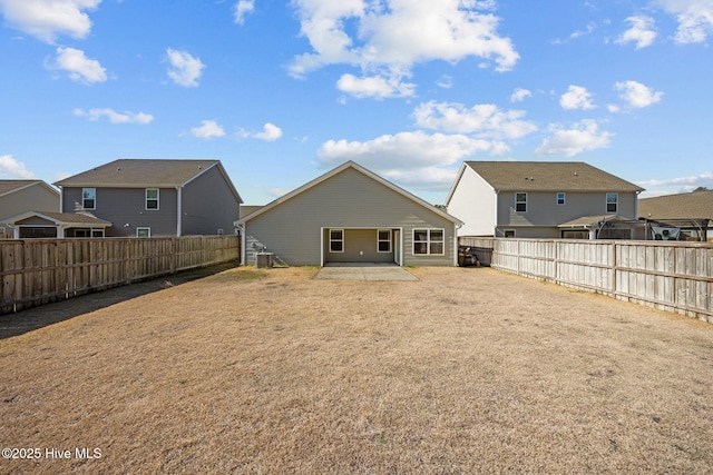 back of property with a residential view, a patio, central AC, and a fenced backyard