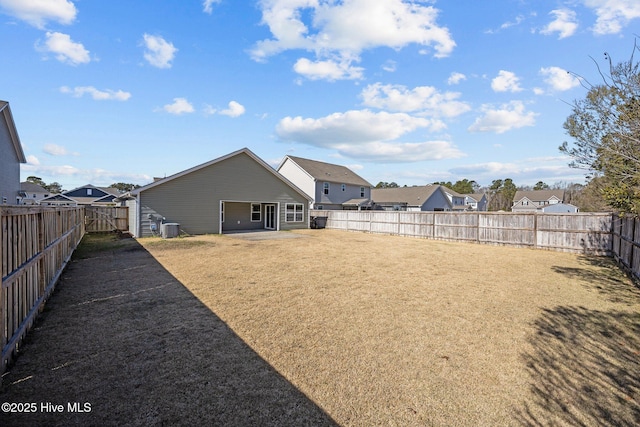 view of yard with central AC unit, a fenced backyard, and a residential view