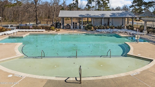 community pool featuring a patio and fence