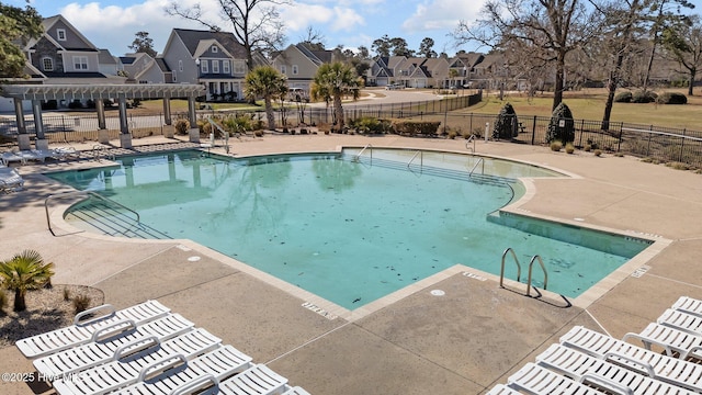 pool featuring a residential view, fence, a patio, and a pergola