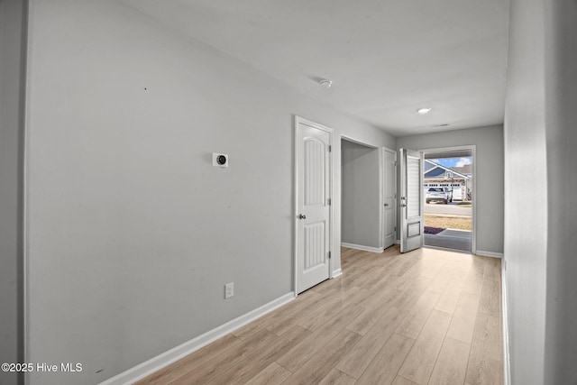 hall featuring baseboards and light wood finished floors