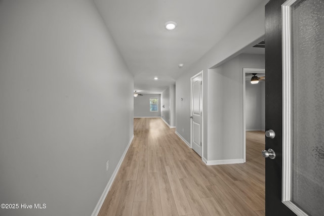 hallway featuring light wood-style floors and baseboards