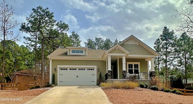 craftsman-style house with concrete driveway, a garage, fence, and covered porch