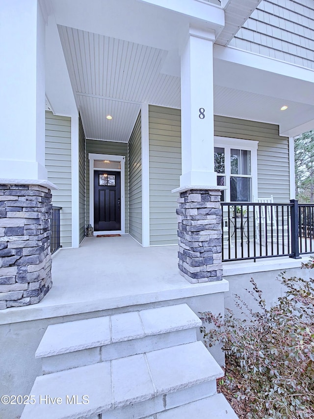 view of exterior entry featuring covered porch