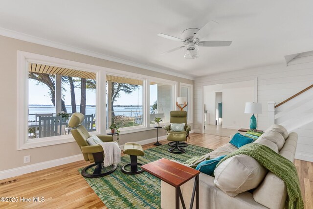 living area with visible vents, ornamental molding, a ceiling fan, and wood finished floors