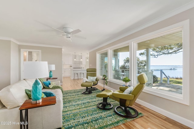 sunroom featuring a water view and ceiling fan