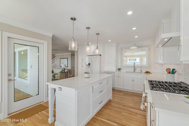 kitchen featuring a sink, white refrigerator with ice dispenser, light wood-style floors, white cabinets, and gas range