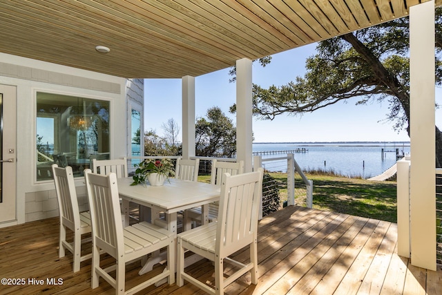 wooden terrace featuring outdoor dining area and a water view