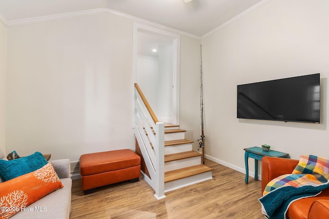 interior space with lofted ceiling, wood finished floors, baseboards, and ornamental molding