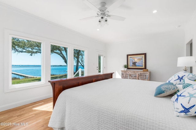 bedroom with light wood-style floors, multiple windows, crown molding, and baseboards