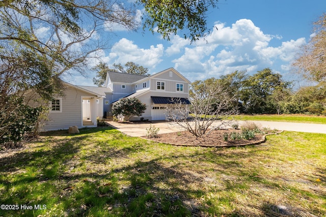 view of front of house with an attached garage, driveway, and a front lawn