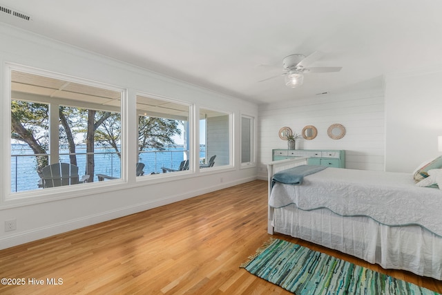 bedroom featuring multiple windows, baseboards, visible vents, and light wood-type flooring