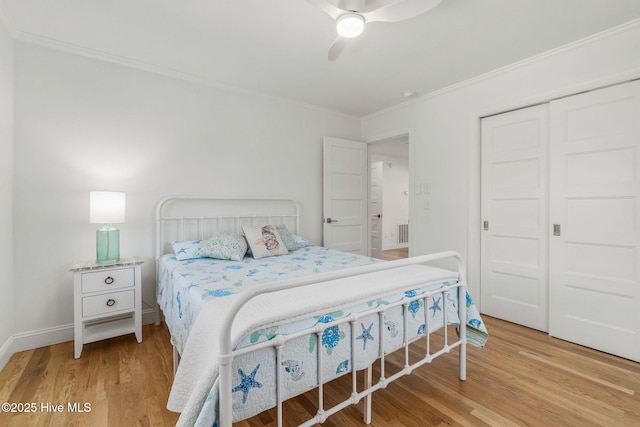 bedroom with wood finished floors, visible vents, ceiling fan, ornamental molding, and a closet