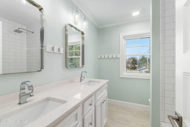 bathroom with double vanity, ornamental molding, baseboards, and a sink