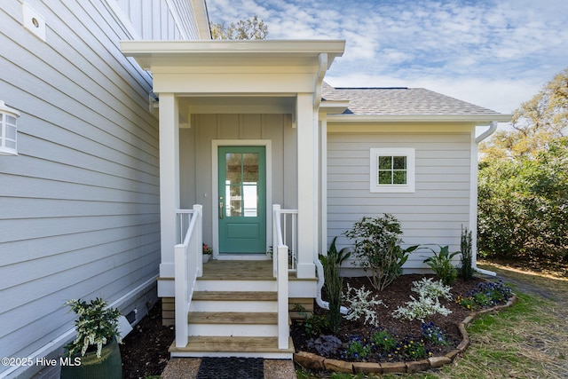 view of exterior entry featuring a shingled roof