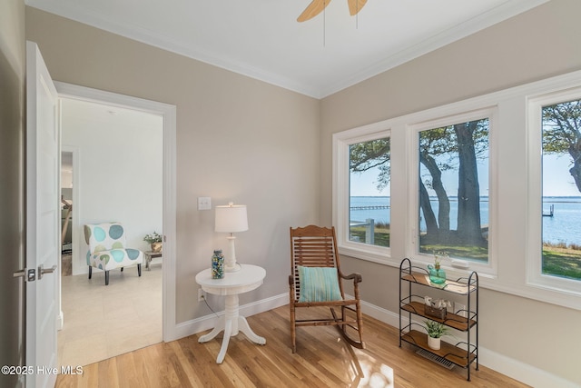 sitting room featuring crown molding, a ceiling fan, baseboards, and light wood finished floors