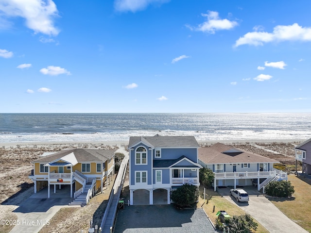 aerial view with a residential view, a view of the beach, and a water view