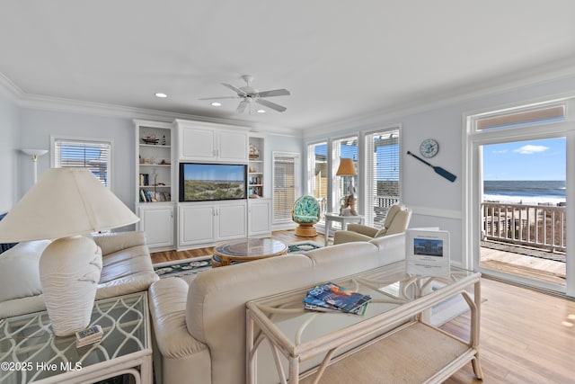 living room with plenty of natural light, recessed lighting, light wood-style floors, and ornamental molding