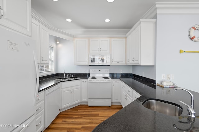 kitchen featuring a sink, white appliances, wood finished floors, and white cabinetry