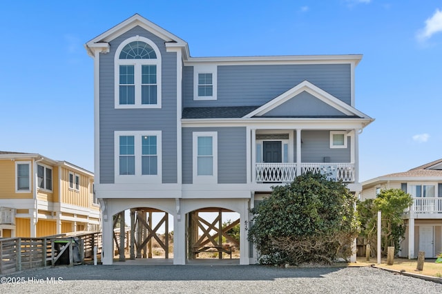 raised beach house with a carport and driveway