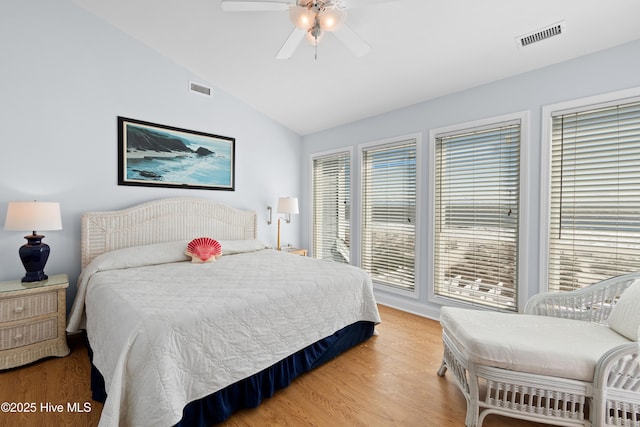 bedroom with light wood finished floors, visible vents, a ceiling fan, and vaulted ceiling