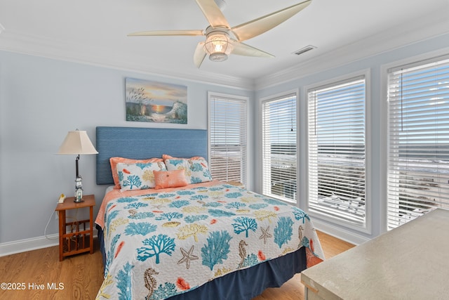 bedroom with light wood-style flooring, multiple windows, visible vents, and ornamental molding