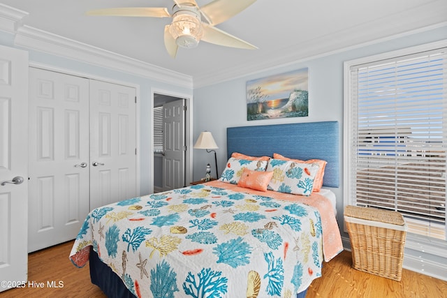 bedroom featuring a ceiling fan, crown molding, wood finished floors, and a closet