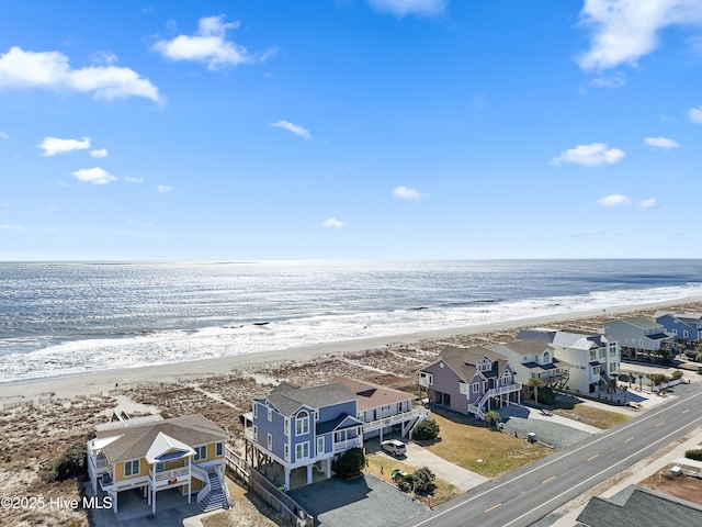 drone / aerial view with a residential view, a water view, and a view of the beach