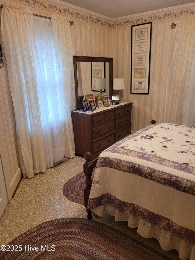 carpeted bedroom featuring crown molding and wallpapered walls