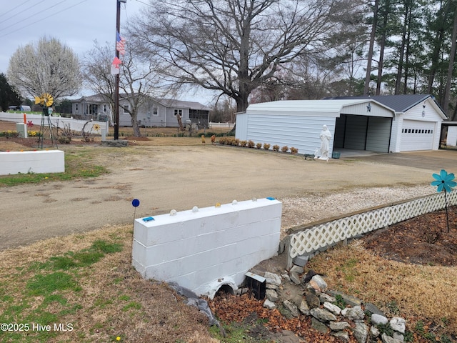 view of yard featuring a garage, an outdoor structure, and fence