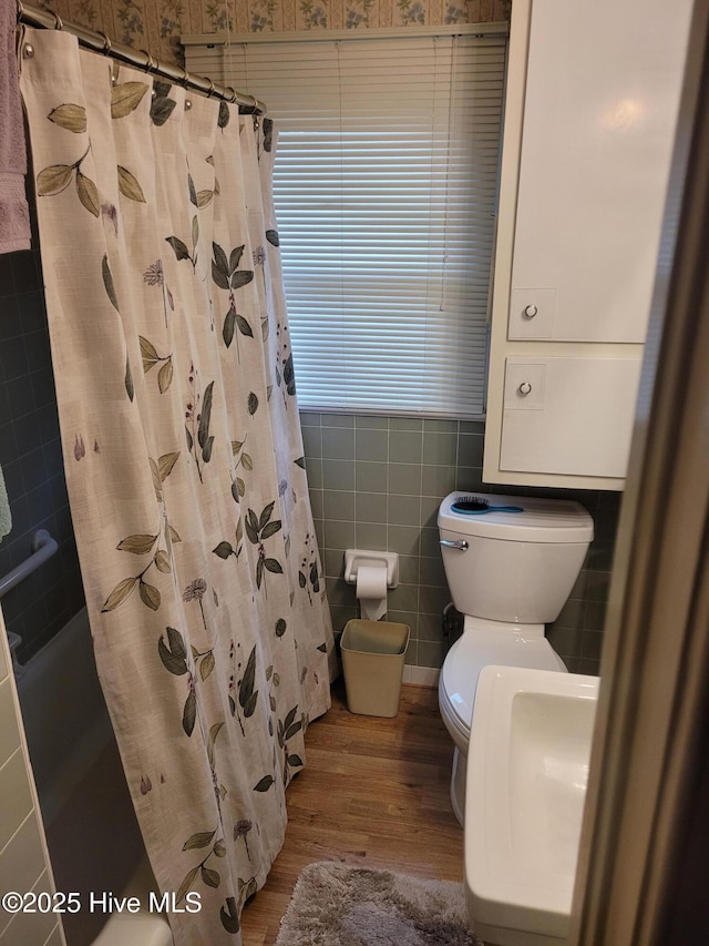 full bathroom with a shower with shower curtain, toilet, tile walls, and wood finished floors