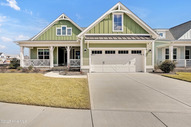 craftsman inspired home with a front yard, driveway, a standing seam roof, a porch, and board and batten siding