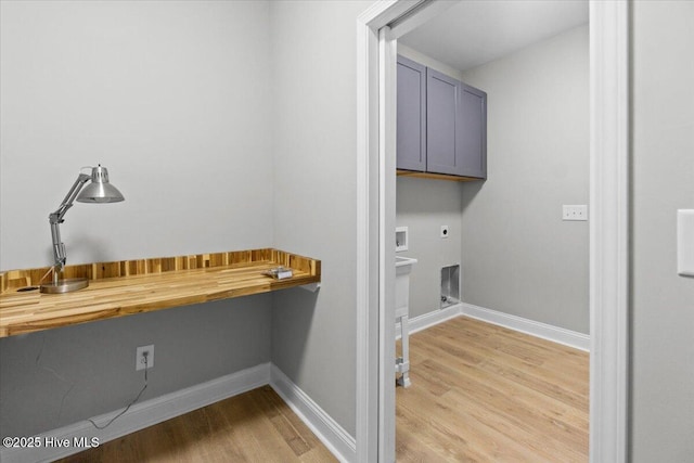 washroom with light wood-style floors, cabinet space, hookup for an electric dryer, and baseboards