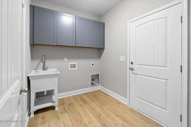 clothes washing area featuring baseboards, cabinet space, electric dryer hookup, washer hookup, and light wood-type flooring