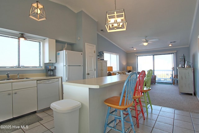 kitchen with white appliances, vaulted ceiling, open floor plan, and a sink