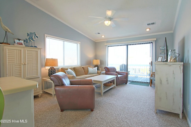 living area featuring a ceiling fan, visible vents, ornamental molding, vaulted ceiling, and light carpet