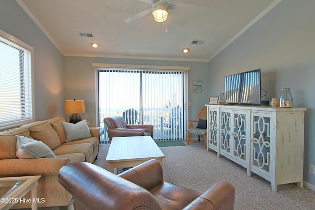 living room with visible vents, light colored carpet, ornamental molding, and a ceiling fan