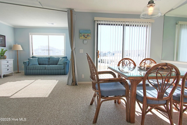 carpeted dining space with visible vents, baseboards, and ornamental molding