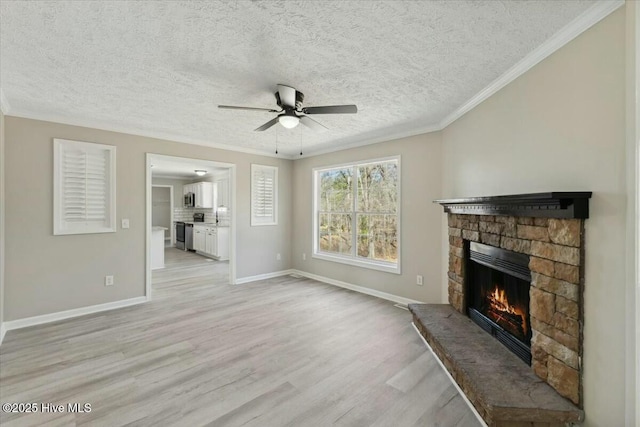 unfurnished living room featuring a stone fireplace, crown molding, light wood-style flooring, and baseboards