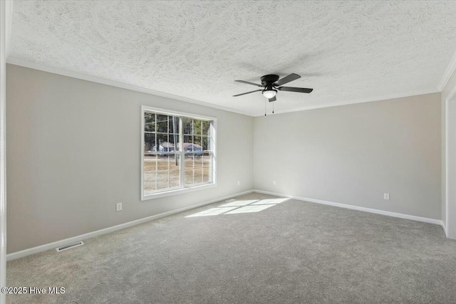 carpeted empty room with visible vents, baseboards, ceiling fan, and ornamental molding