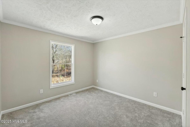 unfurnished room with baseboards, visible vents, carpet floors, and ornamental molding