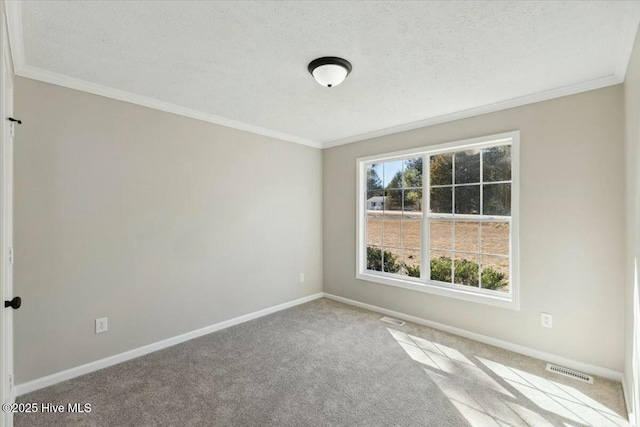 spare room with visible vents, carpet, baseboards, ornamental molding, and a textured ceiling