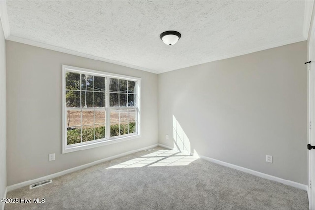 carpeted spare room with visible vents, a textured ceiling, crown molding, and baseboards