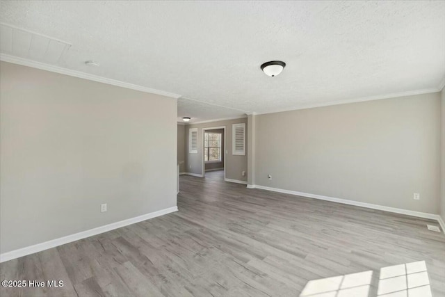 unfurnished room with baseboards, a textured ceiling, wood finished floors, and ornamental molding